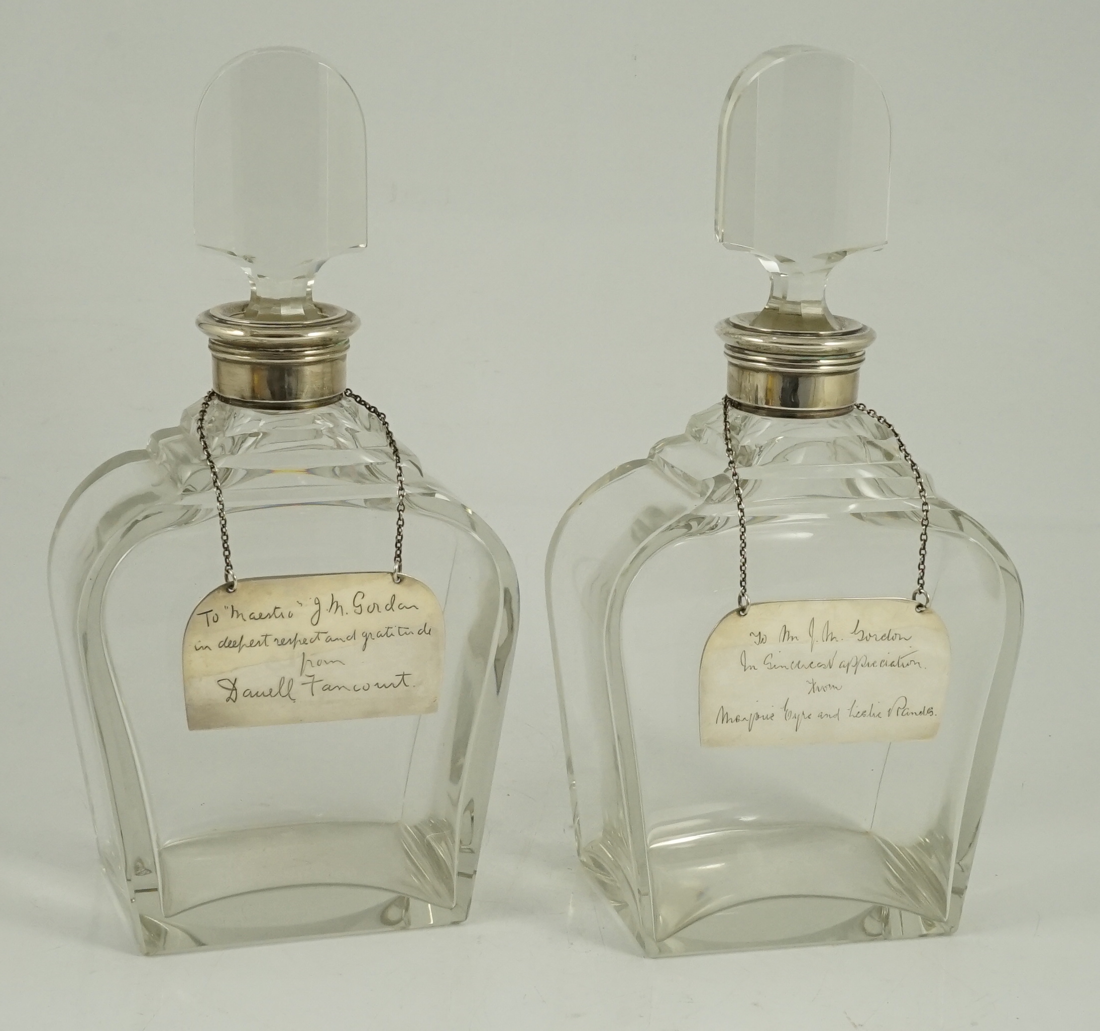 A pair of George VI silver mounted glass decanters and stoppers, by Adie Bros, presented to Mr. J.M. Gordon, to celebrate fifty five years with the D'Oyly Carte Opera Company